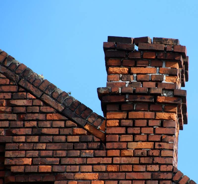 Damaged chimney on an Greenbelt home showing cracks and missing mortar